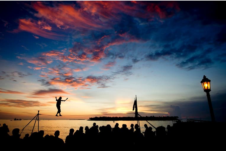 man slack lining at sunset