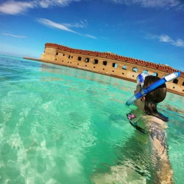 woman snorkeling near old building