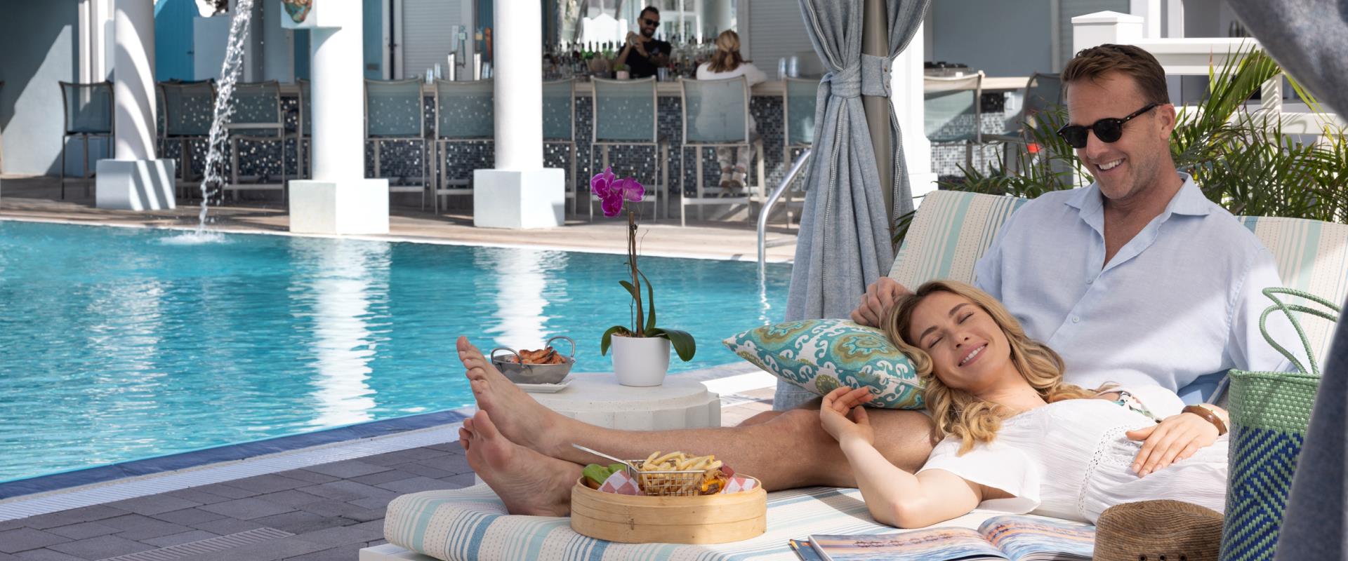 A couple lounging in a pool cabana